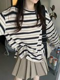Oversized navy-and-cream striped tee with dropped shoulders.