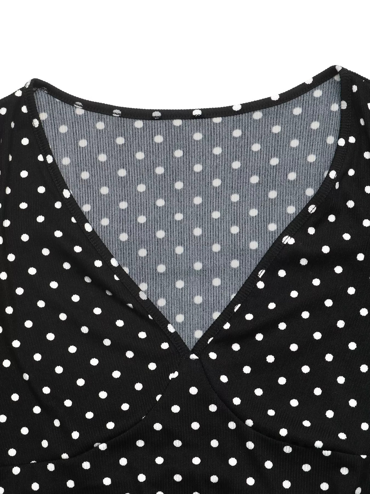 View 7 of the black long-sleeve polka-dot mini dress with a deep V and ruffled cuffs.