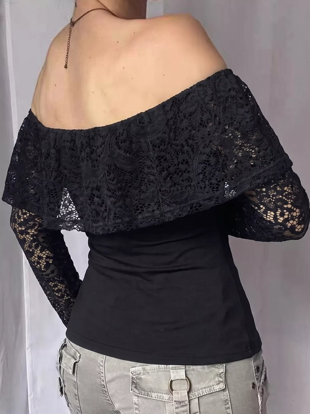 View 5 of the black off-the-shoulder crop top with floral lace at the neck and sleeves.