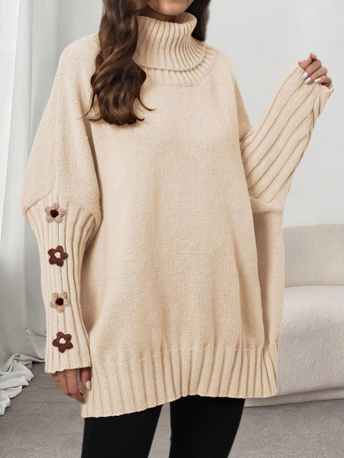 Oversized turtleneck sweater with floral appliqué on the sleeves and ribbed collar and cuffs.