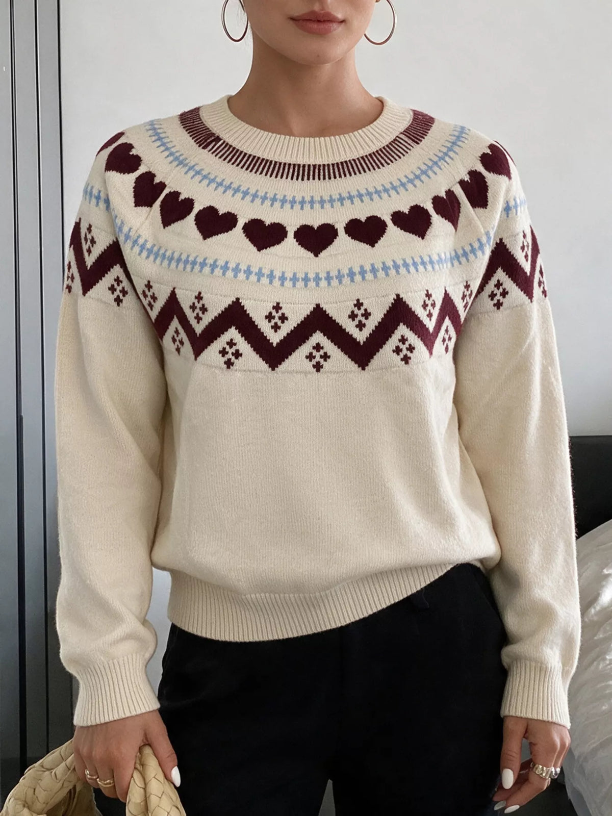 View 2 of the crewneck sweater with a heart pattern through the knit.