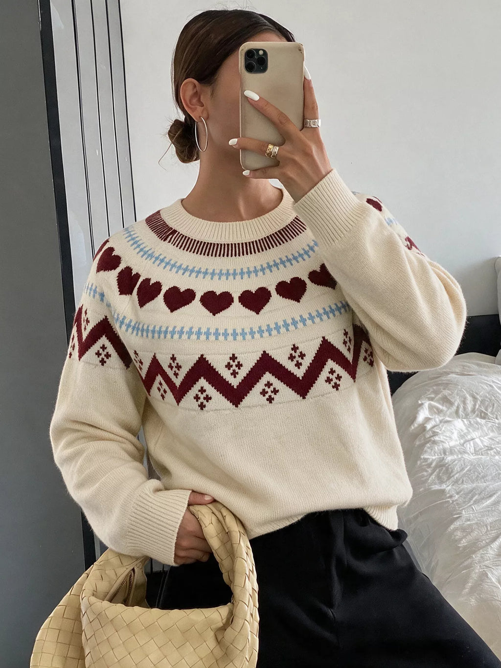 View 3 of the crewneck sweater with a heart pattern through the knit.