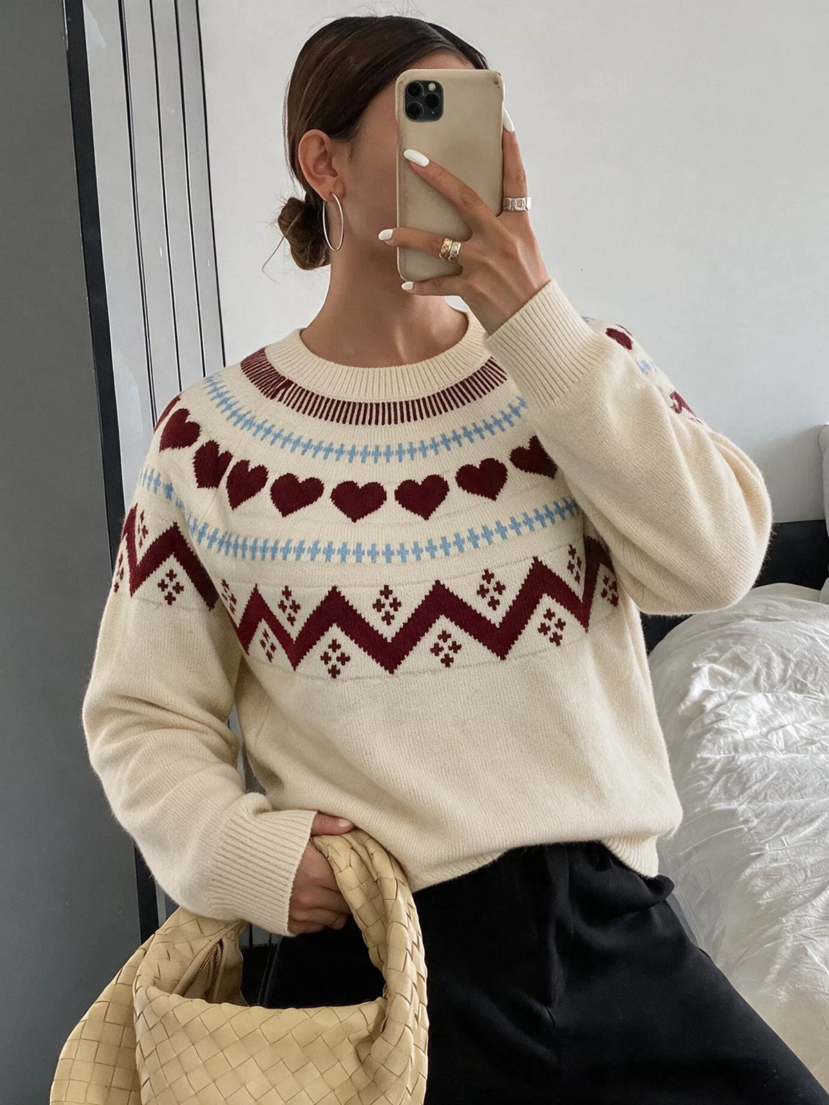 View 3 of the crewneck sweater with a heart pattern through the knit.