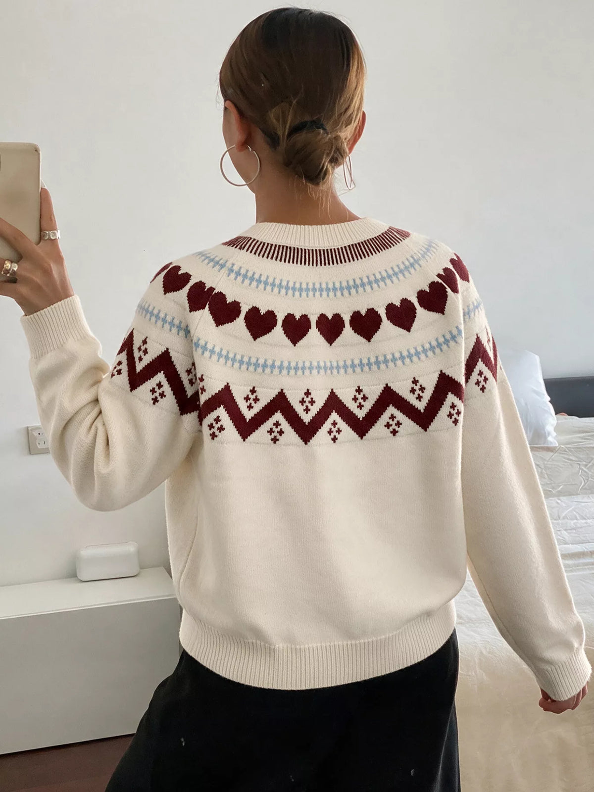 View 7 of the crewneck sweater with a heart pattern through the knit.