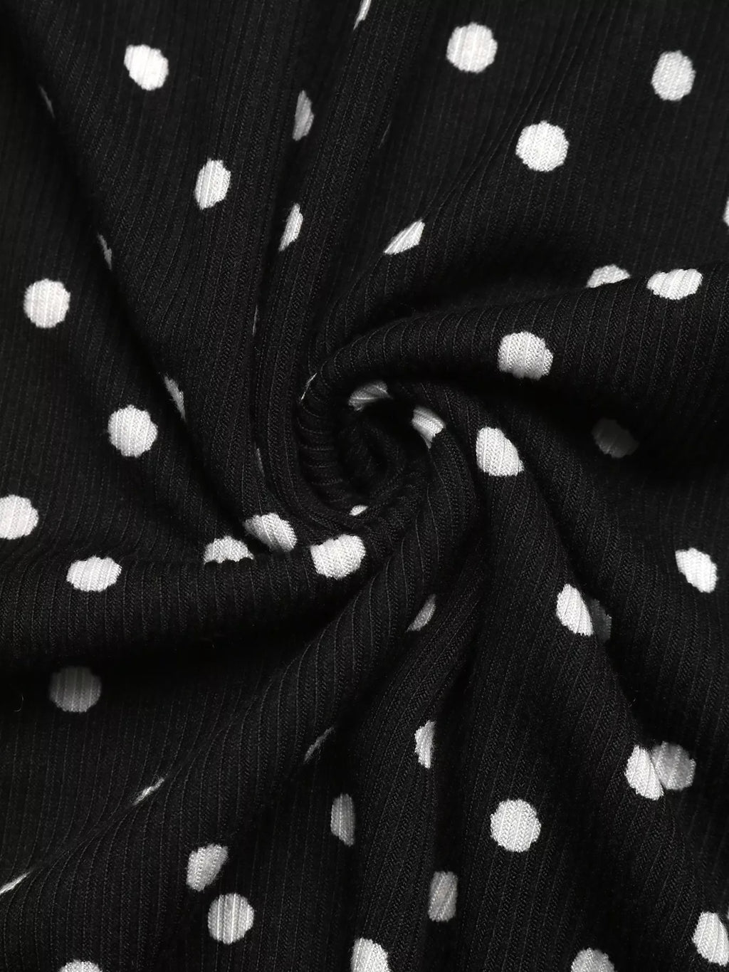 View 11 of the black long-sleeve polka-dot mini dress with a deep V and ruffled cuffs.