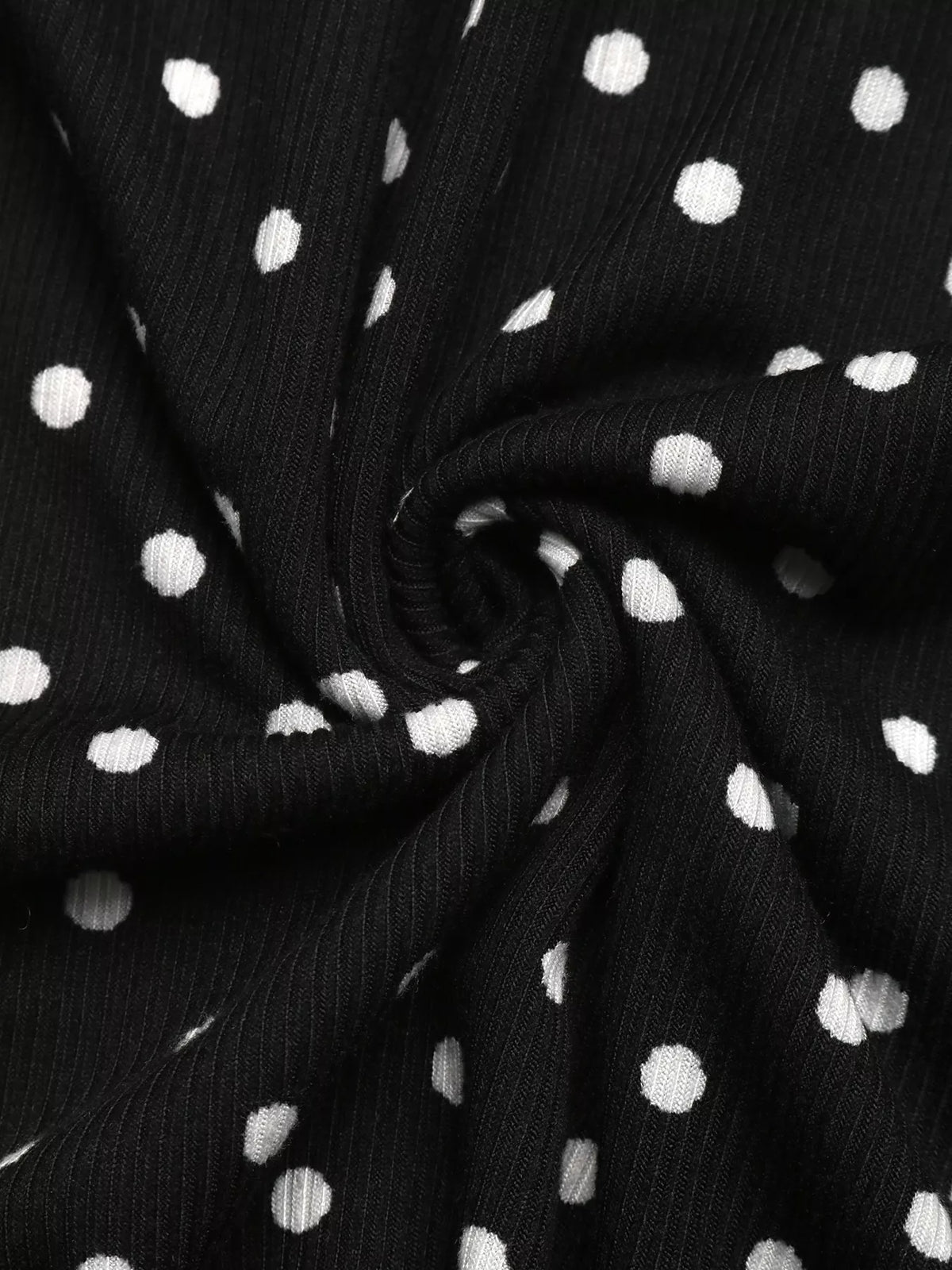 View 11 of the black long-sleeve polka-dot mini dress with a deep V and ruffled cuffs.