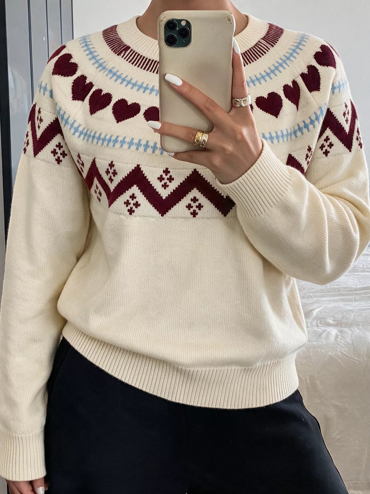 View 6 of the crewneck sweater with a heart pattern through the knit.