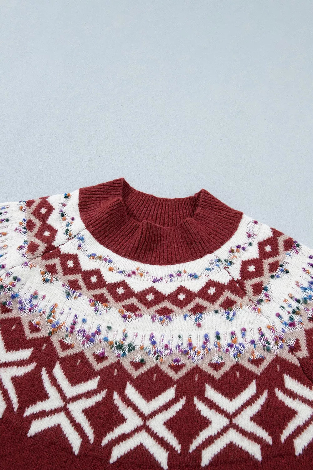 View 8 of the burgundy crewneck sweater with a white snowflake geometric band and a fair-isle yoke.