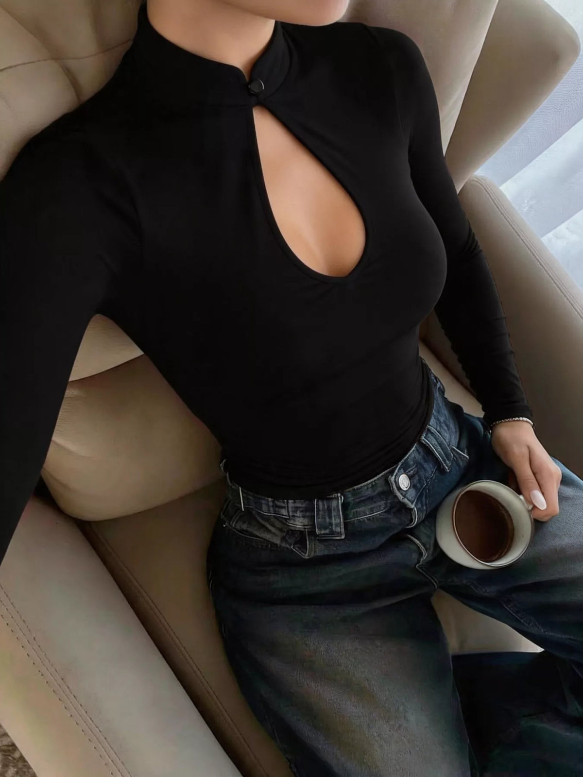 View 2 of the black long-sleeve crop top with a stand collar and a teardrop chest cutout.