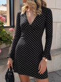 Black long-sleeve polka-dot mini dress with a deep V and ruffled cuffs.