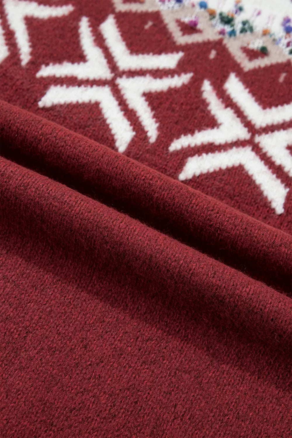View 11 of the burgundy crewneck sweater with a white snowflake geometric band and a fair-isle yoke.