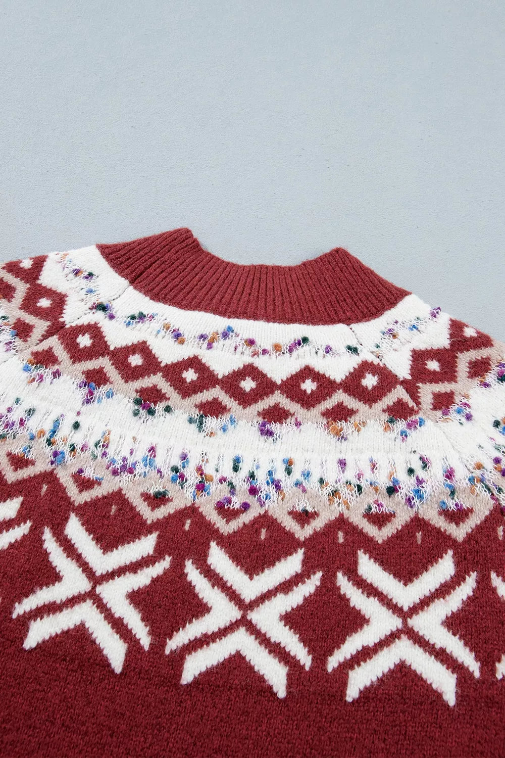View 9 of the burgundy crewneck sweater with a white snowflake geometric band and a fair-isle yoke.