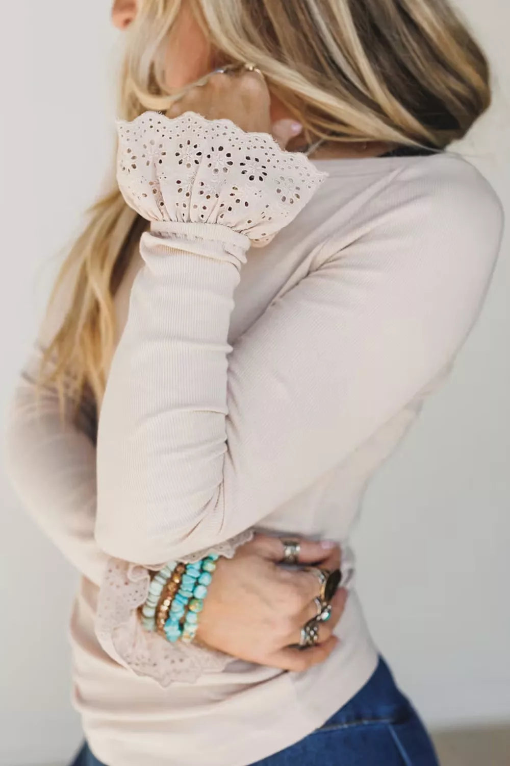 View 3 of the fitted beige ribbed long-sleeve top with eyelet lace cuffs.