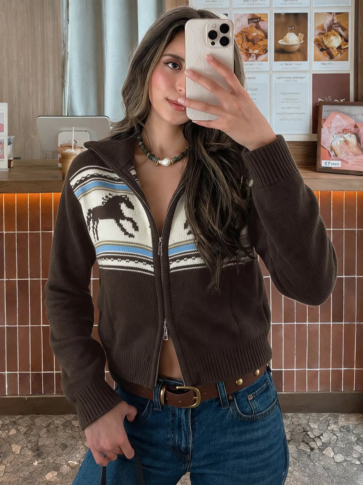 View 2 of the brown zip mock-neck cardigan with black horses on a cream chest band.